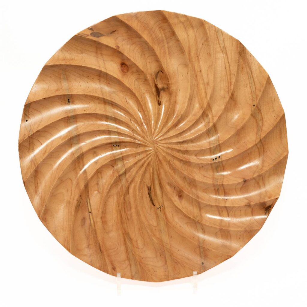 Round Wooden Plate with a Swirling Carved Pattern