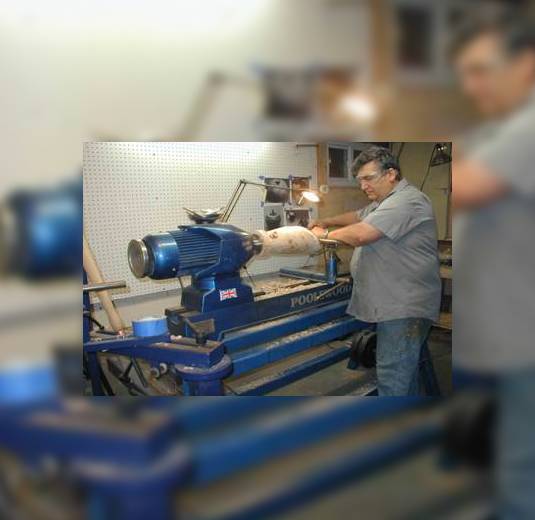 A Man Working on a Wood Lathe in a Workshop