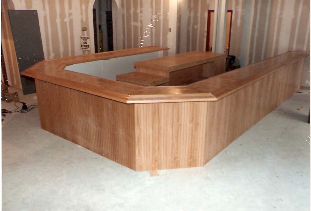 A Large Unfinished Wooden Bar Structure with a Wraparound Counter and Paneled Sides